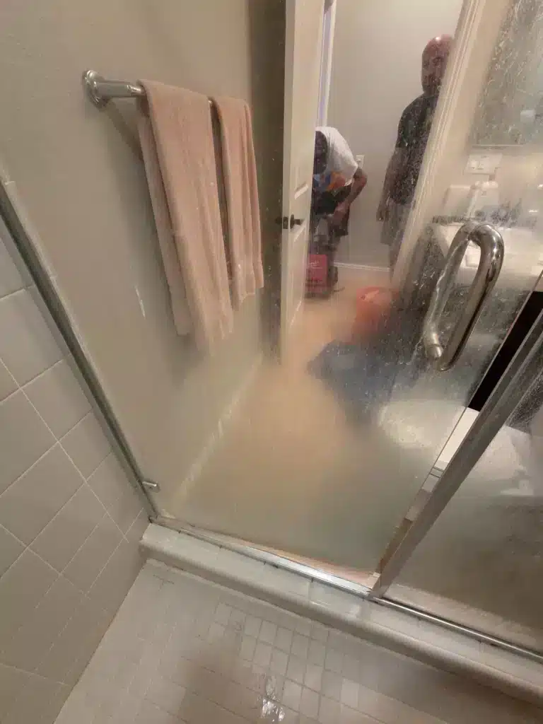 Framed shower door before restoration, so cloudy the towel bar and doorway behind it are blurred